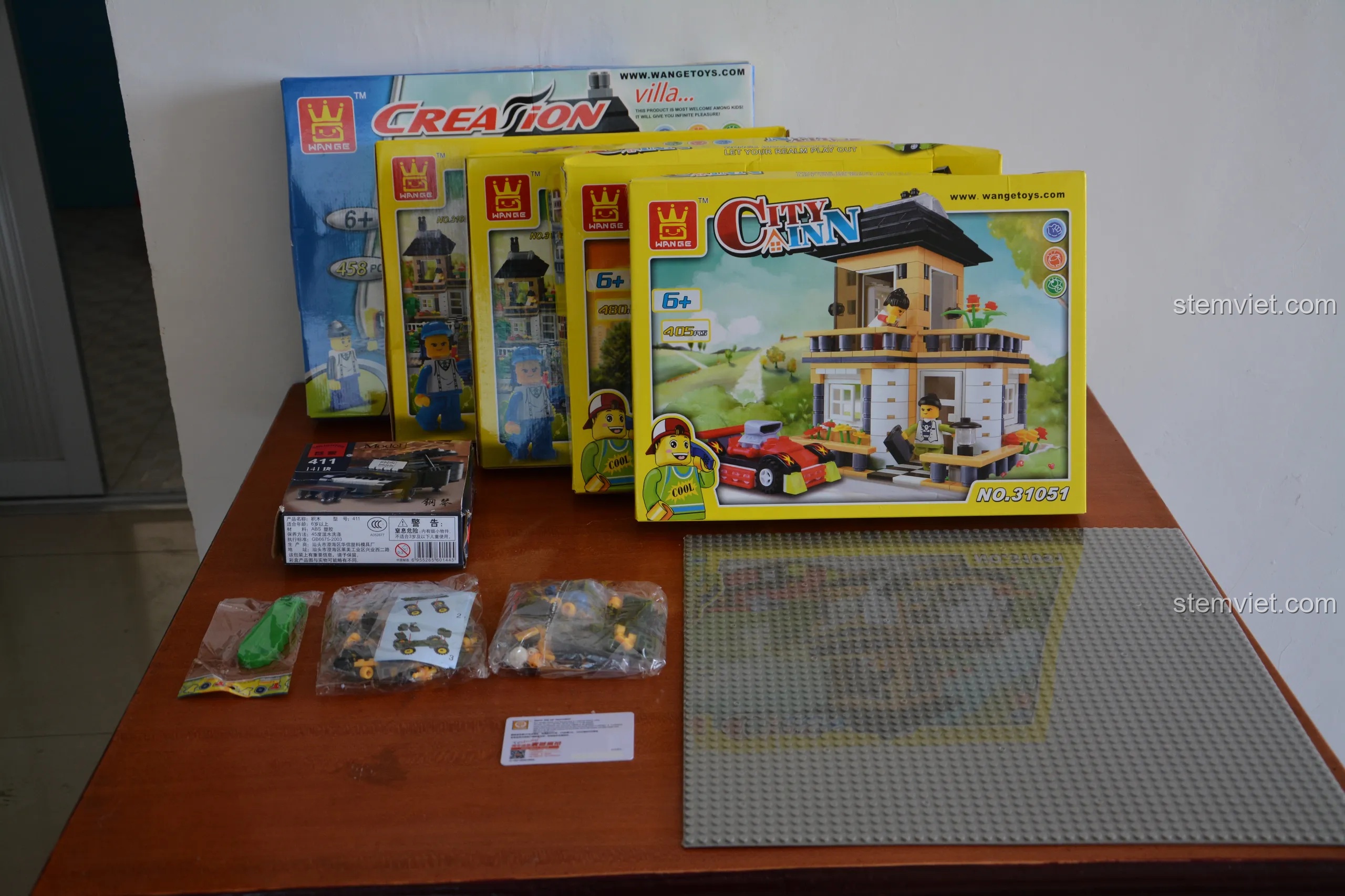 Toàn bộ các bộ phận của combo nhà phố WANGE được bày ra, bao gồm 5 hộp nhà, đế lớn, và các túi phụ kiện nhỏ.