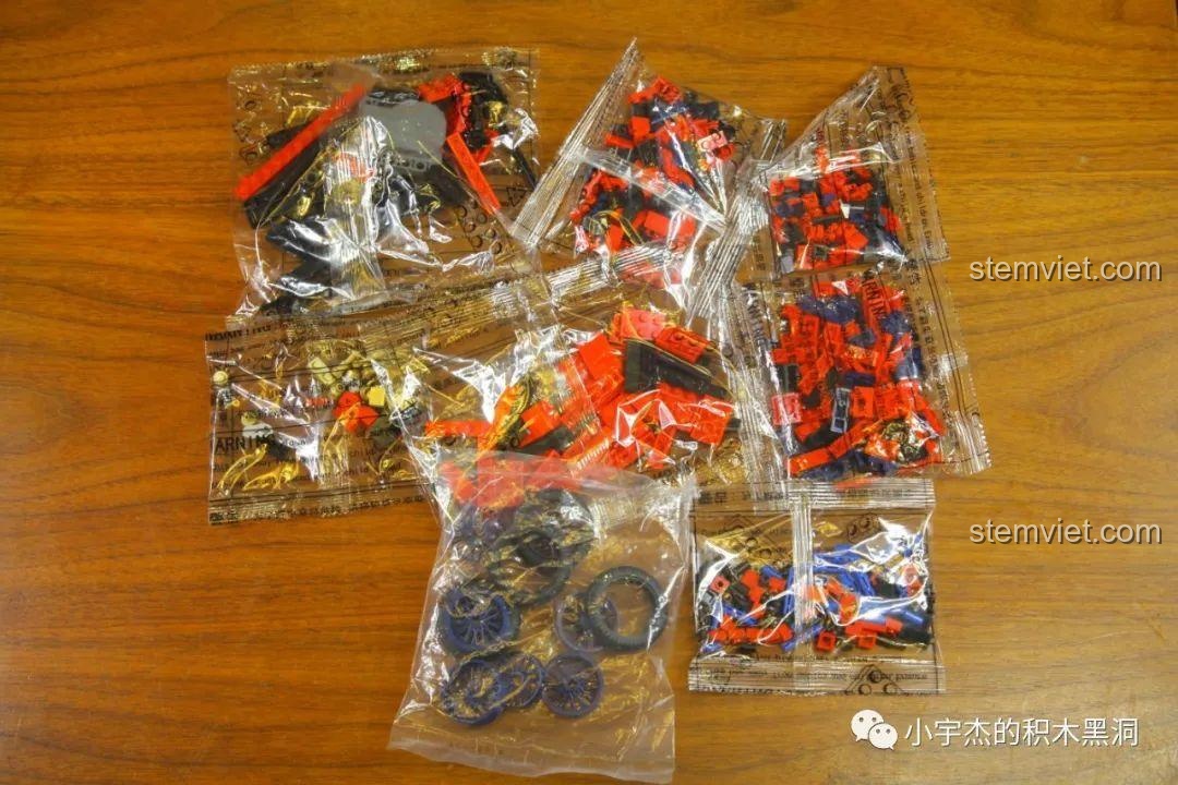 Toàn bộ các túi mảnh ghép của bộ lắp ghép Xe Duryea Runabout L 705400 được bày ra trên bàn gỗ.