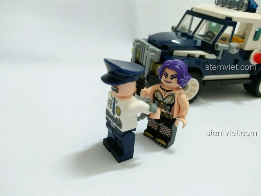 Nữ tội phạm Diana bị còng tay bởi cảnh sát Jim, với biểu cảm bất cần trên khuôn mặt.