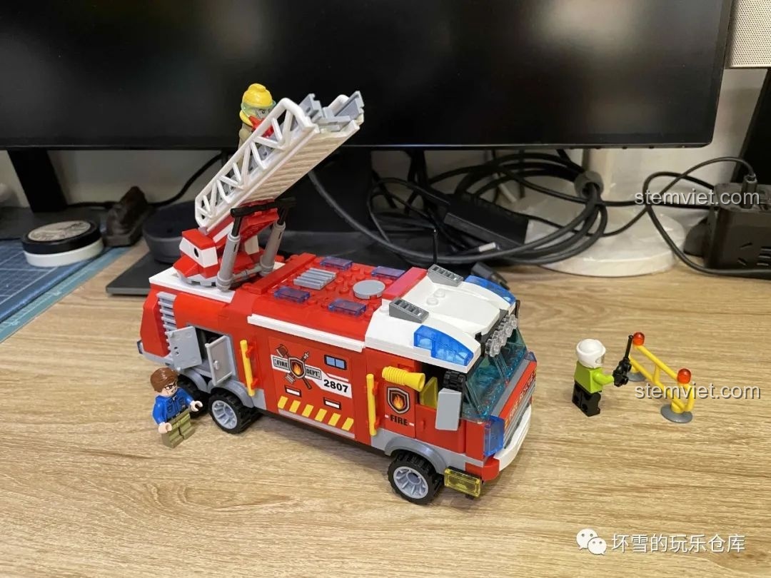 Mô hình xe cứu hỏa QMAN 2807 cùng các minifigures được sắp xếp trong một kịch bản vui chơi.