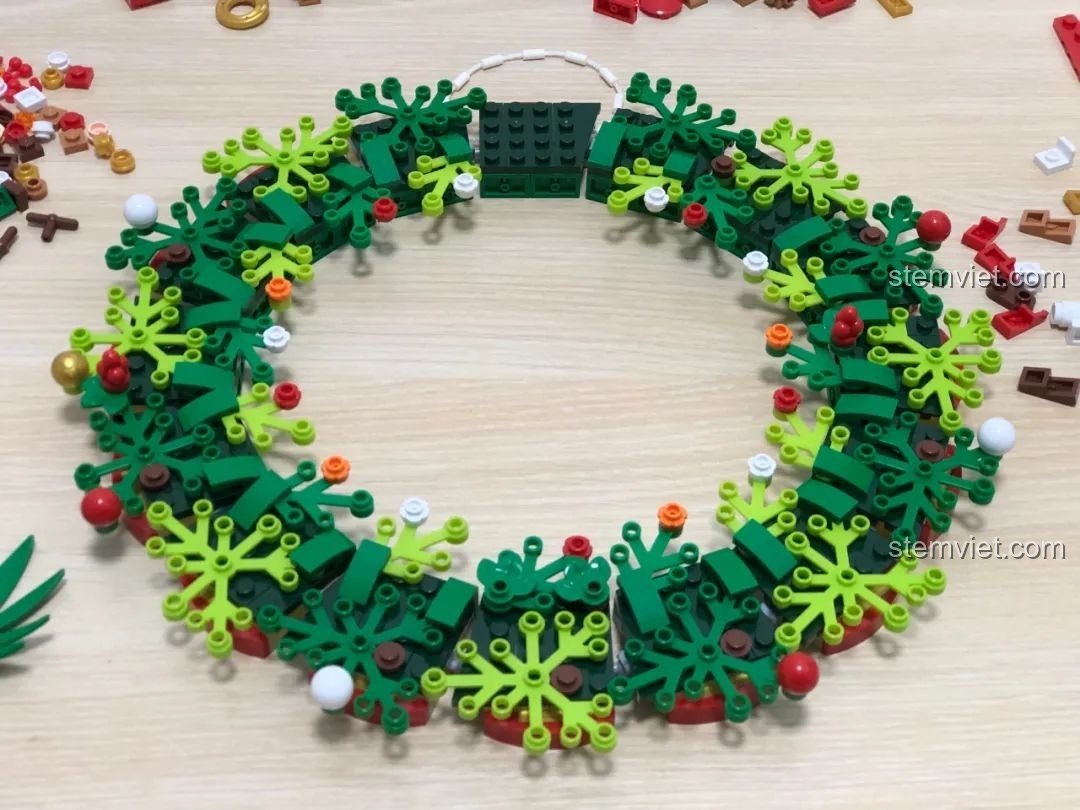 Trang trí cây xanh trên vòng hoa Giáng Sinh JAKI JK5118, các chi tiết lá cây được lắp ráp tỉ mỉ.