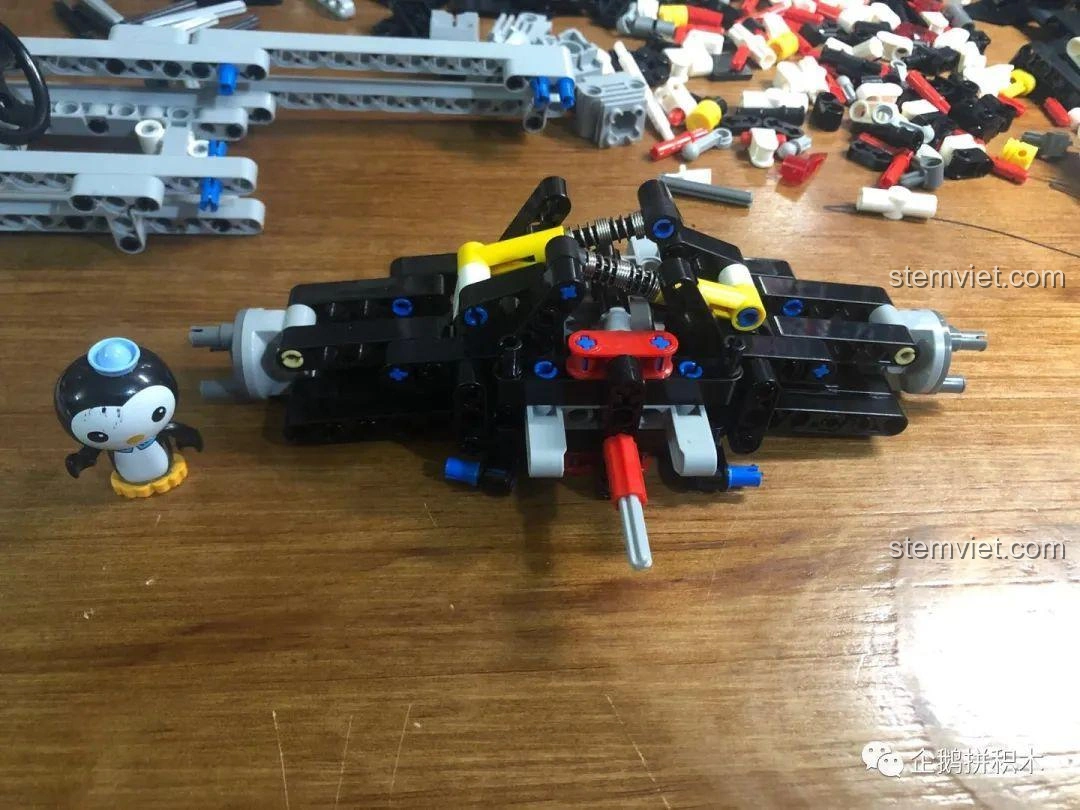 Cận cảnh phần trục sau và hệ thống treo của mô hình xe đua F1 Mould King 13117 đang được lắp ráp.