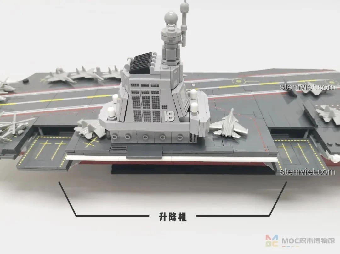 Trực thăng được đặt trên thang nâng của mô hình tàu sân bay Sluban M38-B1188, thể hiện khả năng vận chuyển đa dạng.