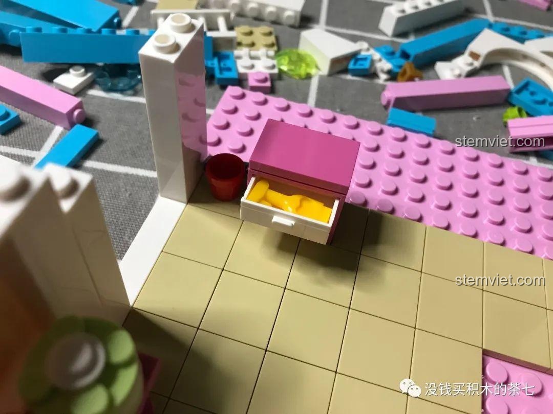 Chiếc tủ đầu giường màu hồng với ngăn kéo chứa chuối trong bộ đồ chơi Lâu Đài Phép Thuật.