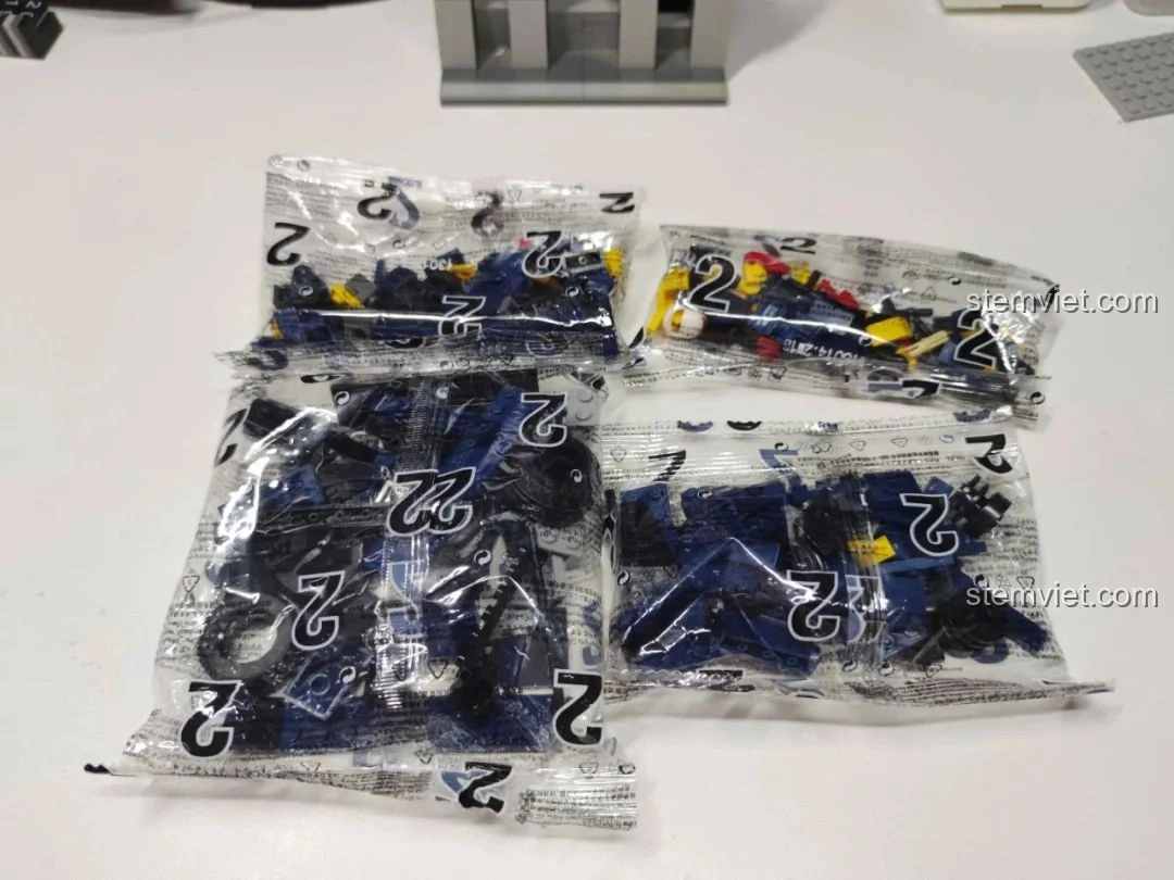 Các túi mảnh ghép được đánh số của bộ MJ Technology 13014, phân loại theo từng xe đua F1 màu cam.