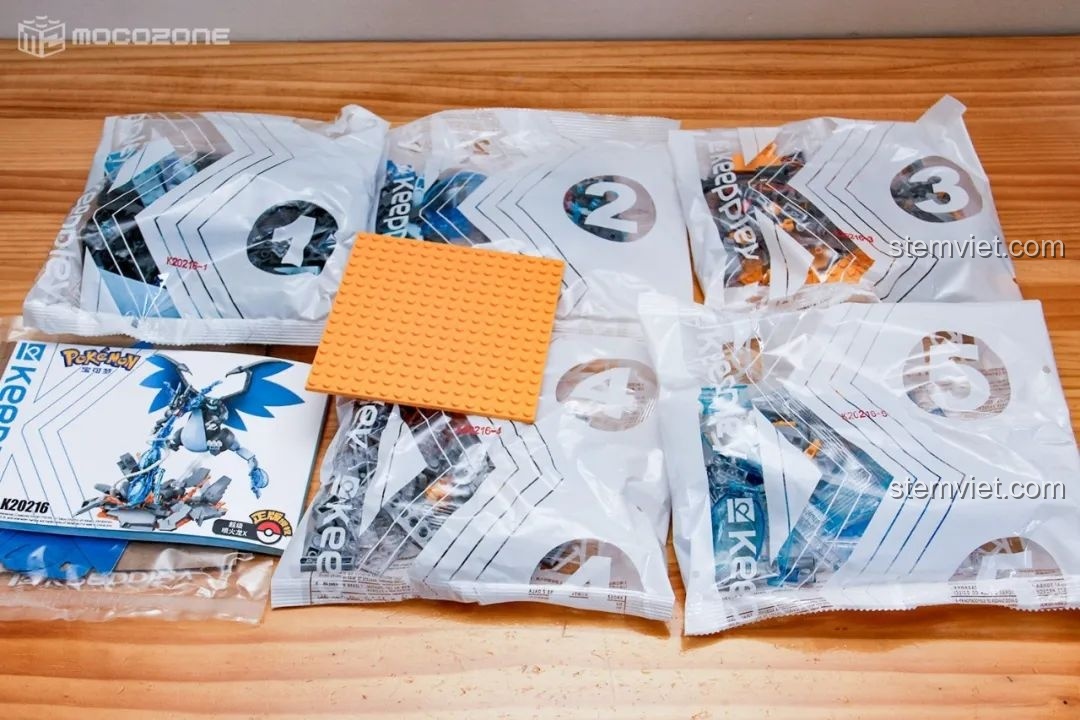 Unbox bộ lắp ráp Siêu Charizard X K20216, gồm 5 túi chi tiết, đế và sách hướng dẫn.