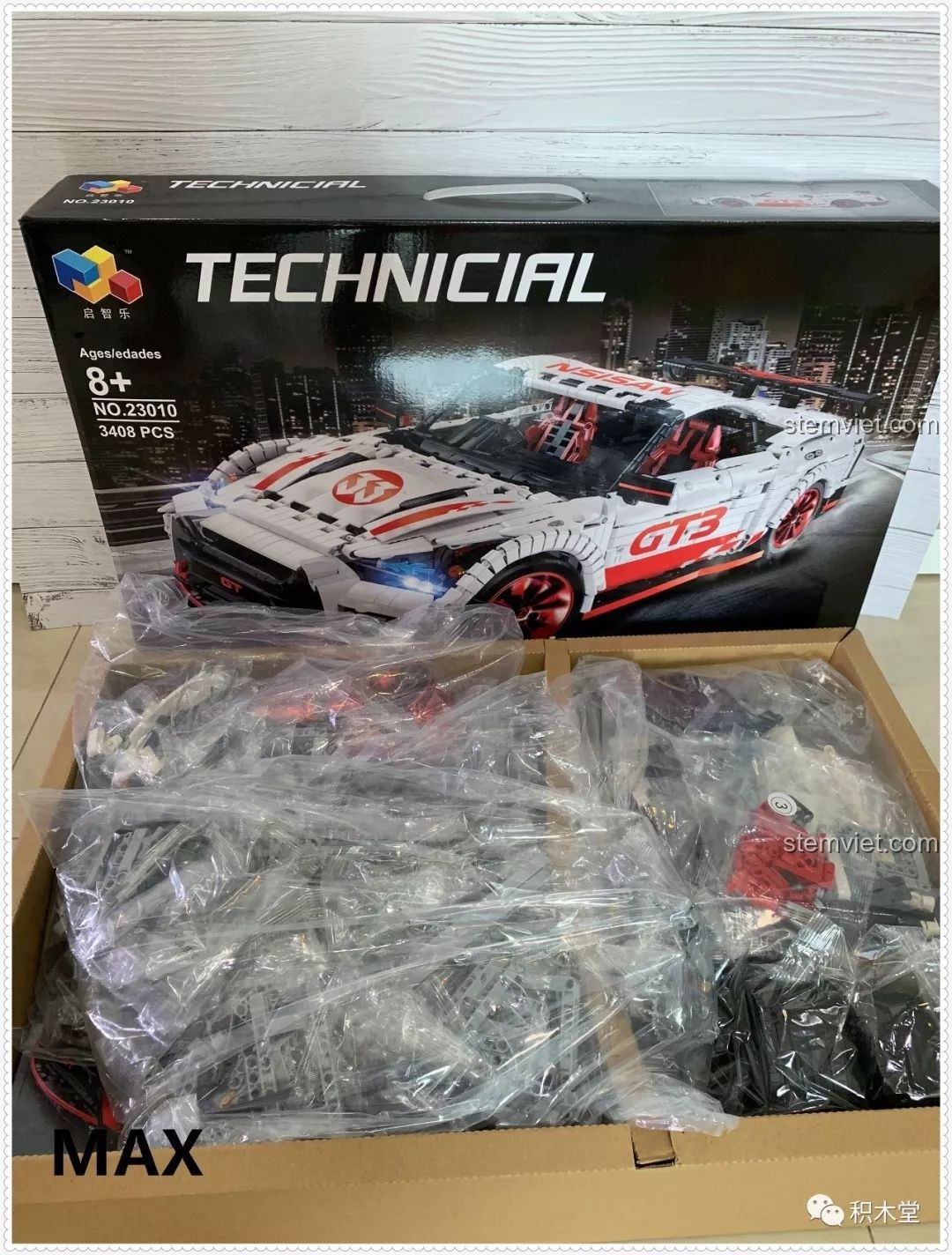 Mở hộp bộ lắp ráp Qizhile 23010 Nissan GT-R, cho thấy các túi mảnh ghép được đóng gói riêng biệt bên trong.