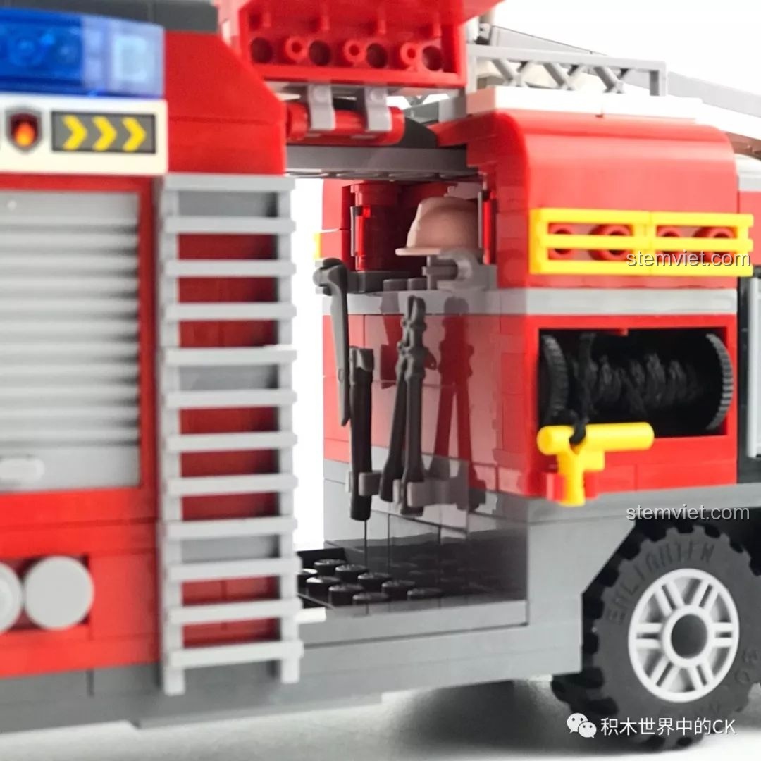 Minifigure lính cứu hỏa đang sử dụng vòi phun có thể kéo ra từ bên hông xe cứu hỏa QMAN 2809.