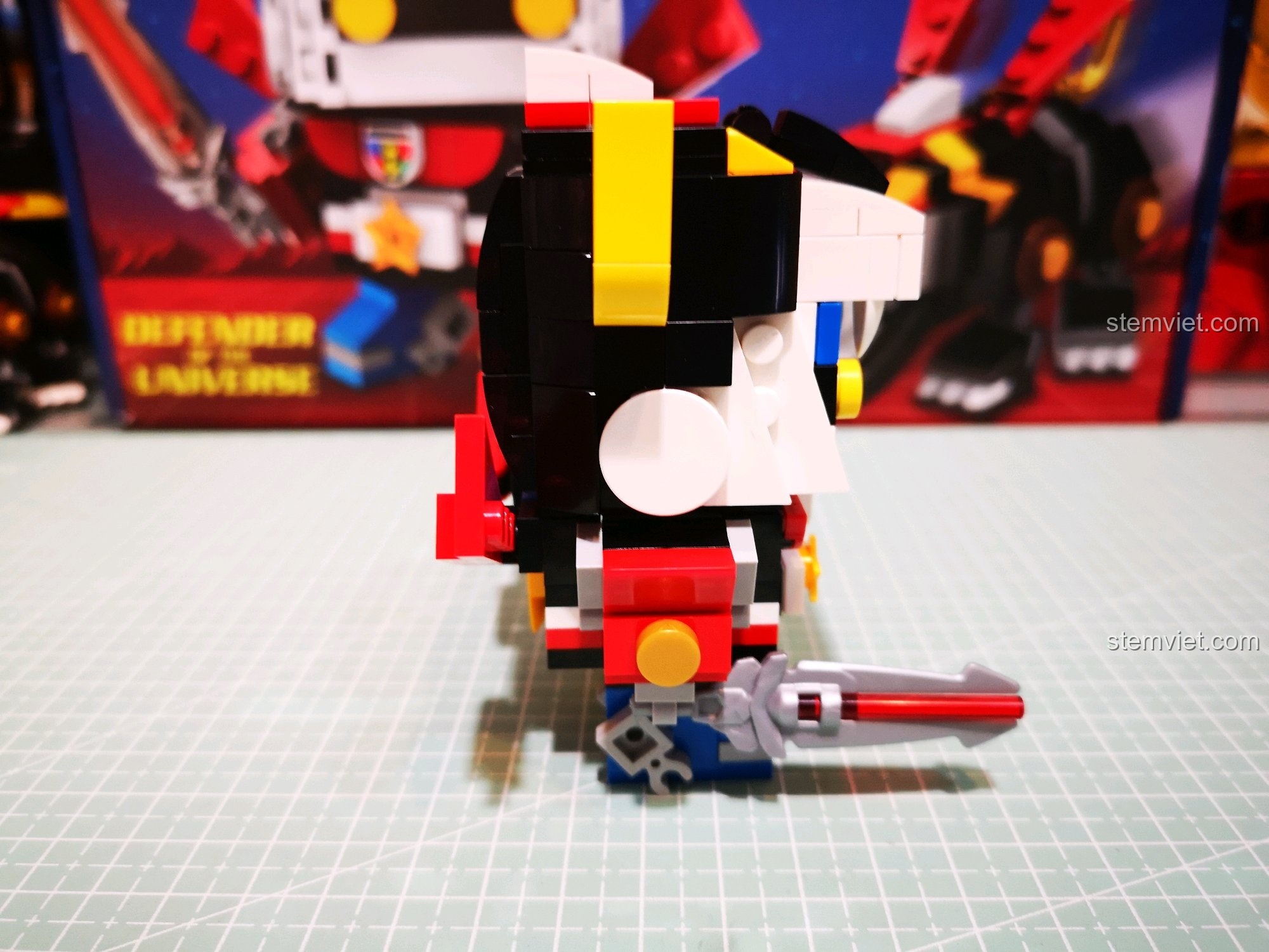 Góc nhìn bên hông của mô hình Voltron, thấy rõ cánh tay Đỏ cầm gươm.
