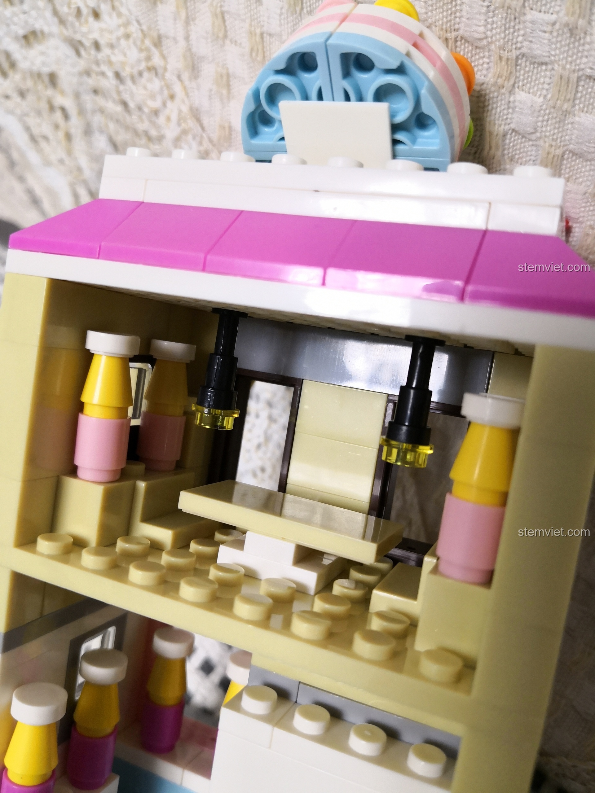 Bé gái 6 tuổi đang thích thú với bộ lắp ráp WANGE 2311 Cửa hàng bánh ngọt mini.