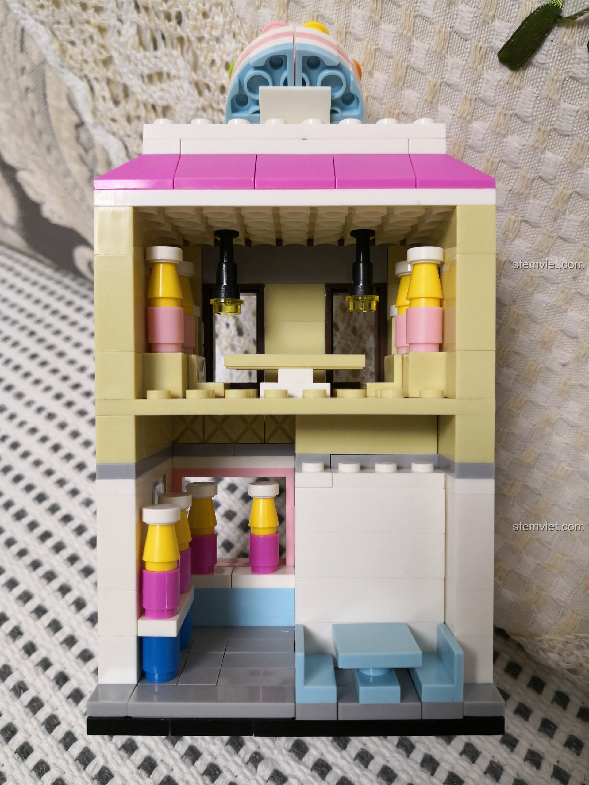 Không gian bên trong bộ lắp ráp WANGE 2311 Cửa hàng bánh ngọt mini, có quầy bánh và bàn ghế.