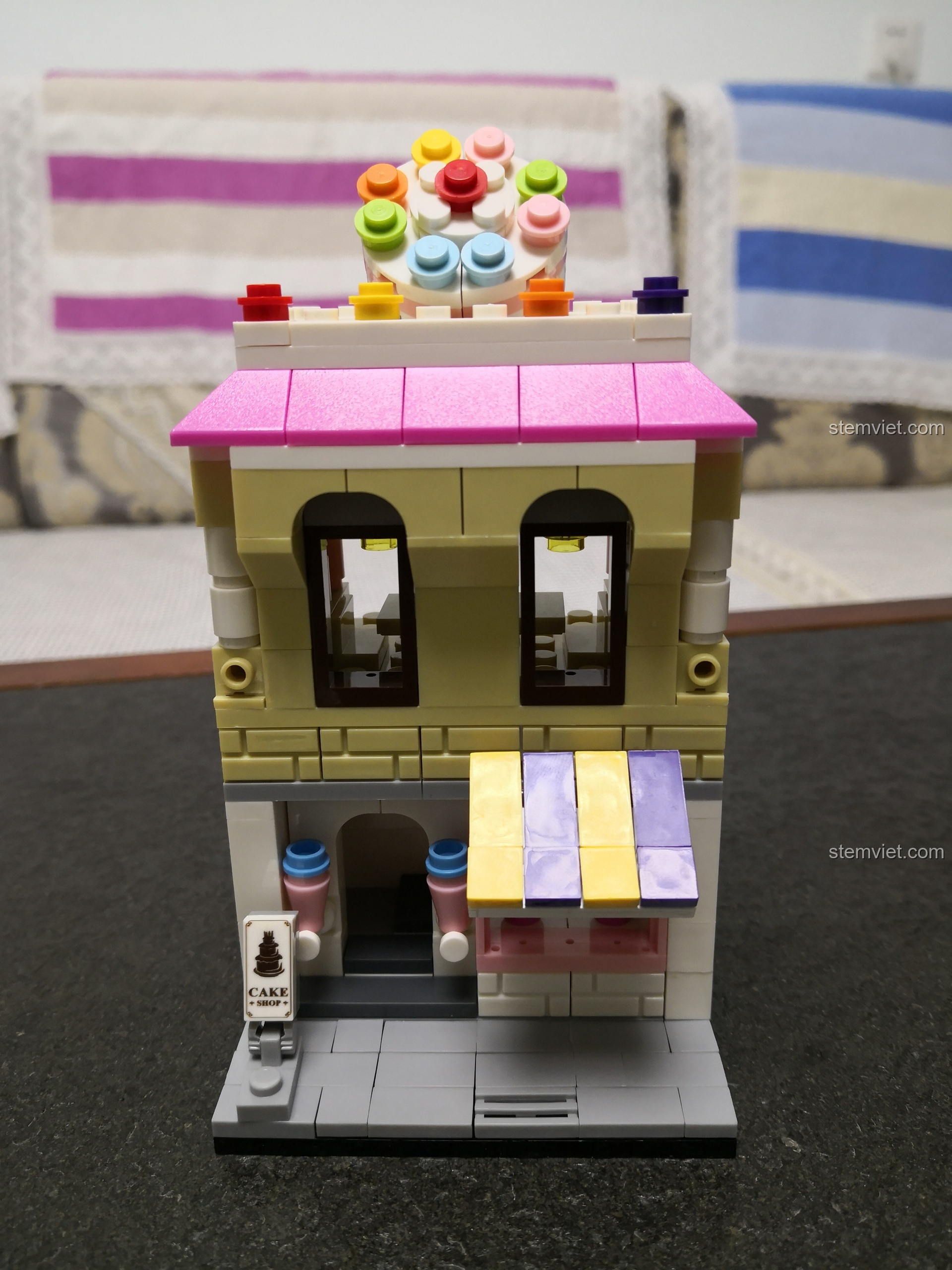 Tổng quan bộ lắp ráp WANGE 2311 Cửa hàng bánh ngọt mini, với mặt tiền màu vàng và mái hồng nổi bật.