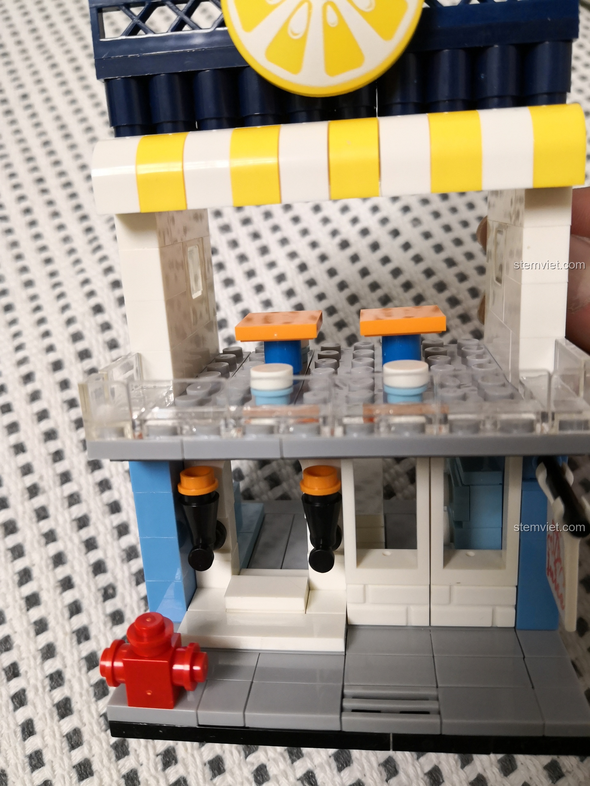 Bên trong tầng trên của cửa hàng nước ép WANGE 2312 với hai bộ bàn ghế nhỏ.