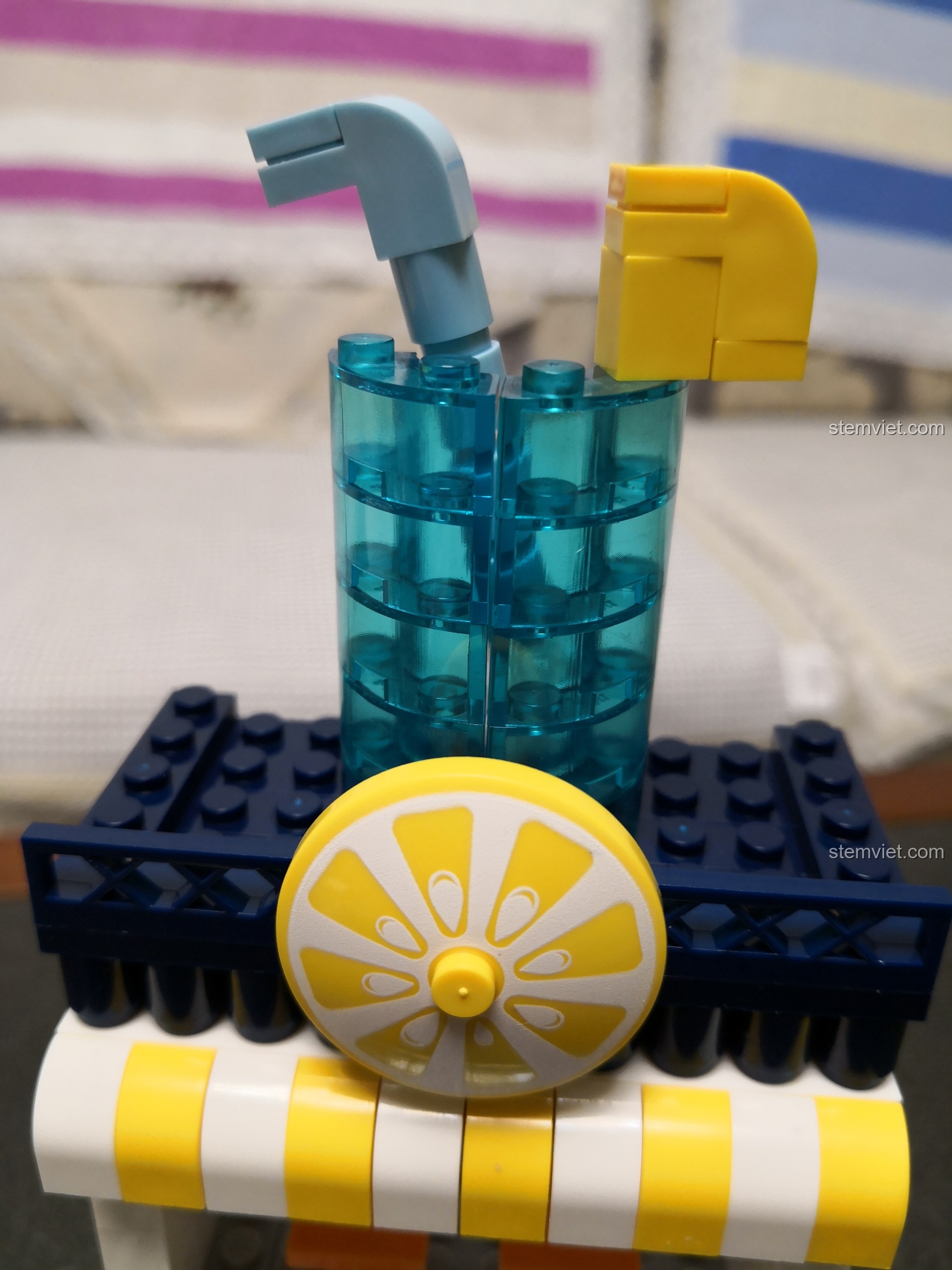 Cận cảnh ly nước ép màu xanh trong suốt và lát chanh vàng tươi trên nóc cửa hàng WANGE 2312.