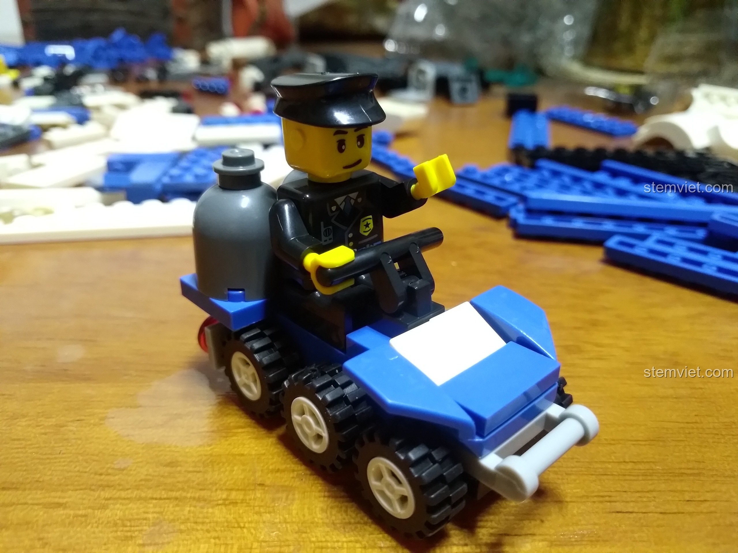 Minifigure cảnh sát ngồi trên chiếc xe địa hình mini màu xanh dương của bộ WANGE 52015.