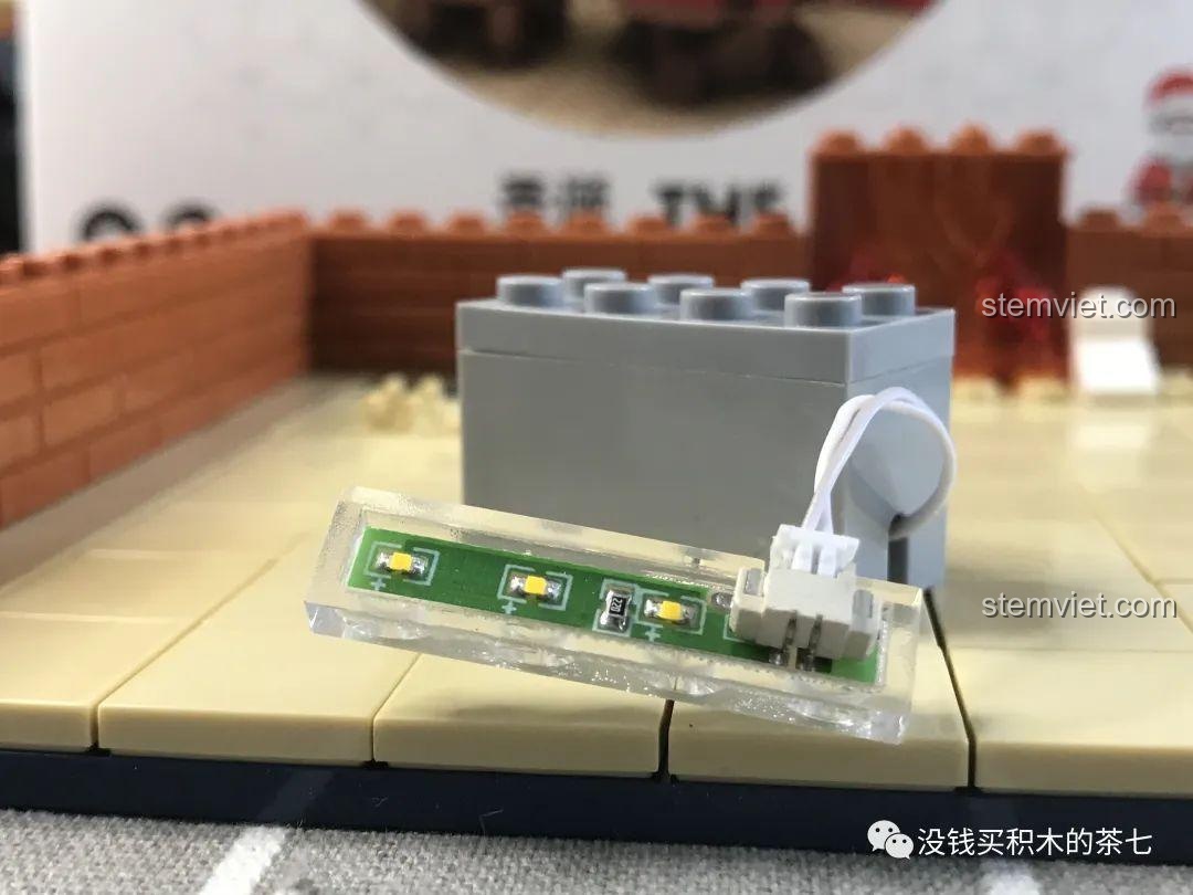 Lắp ráp lò sưởi bộ xếp hình Wekki 506001 Phòng Tiệc Giáng Sinh, với các chi tiết lửa màu cam trong lò.