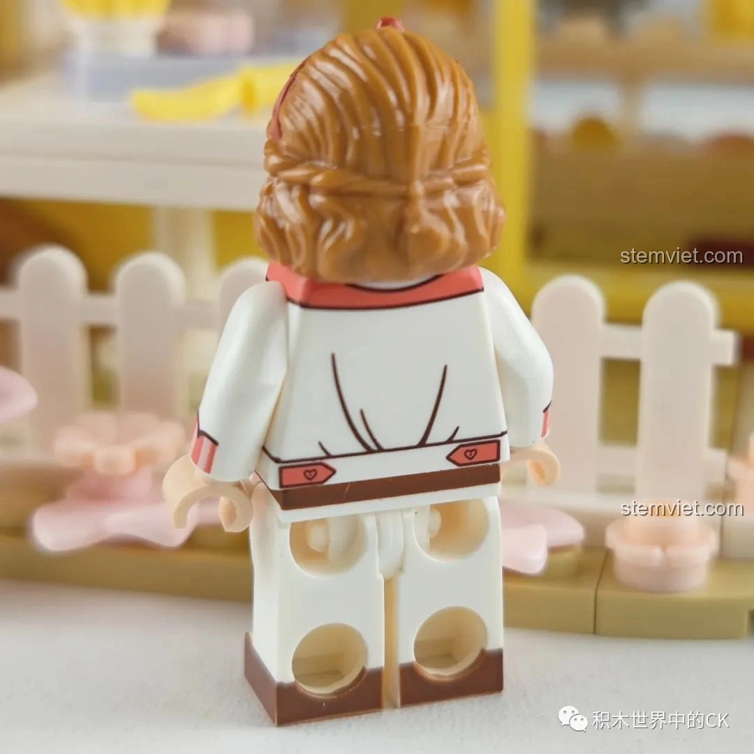 Minifigure cô chủ tiệm bánh trong bộ Wekki 516601 Tiệm Bánh Ngọt Hoa Anh Đào nhìn từ phía sau, thấy rõ chi tiết tóc và trang phục.