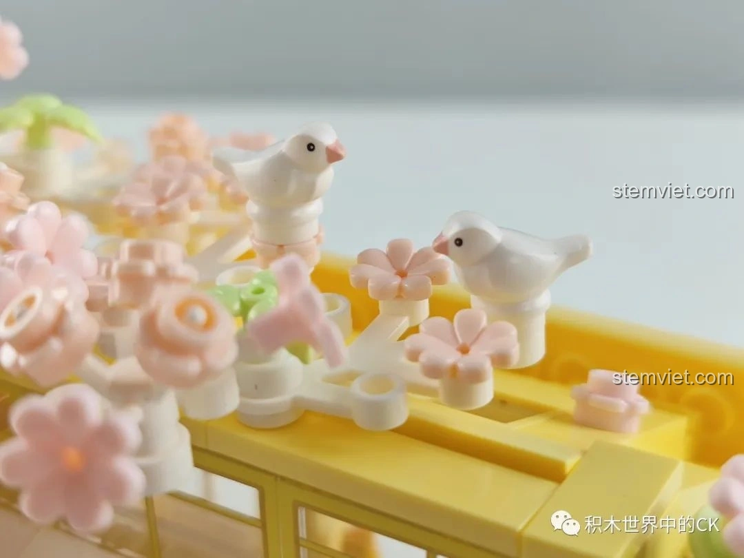 Bộ lắp ghép Wekki 516601 Tiệm Bánh Ngọt Hoa Anh Đào đặt cạnh mô hình xe ngựa cổ tích và nhân vật khác.