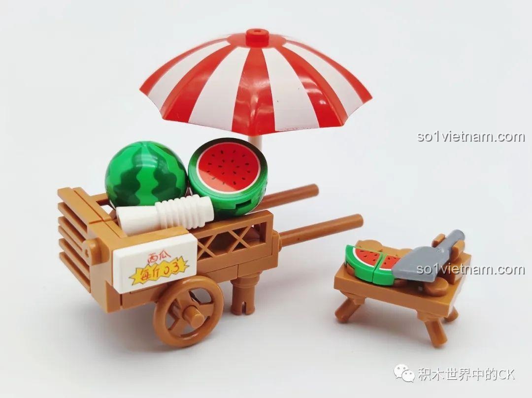 Cận cảnh xe đẩy dưa hấu Wekki 516852A với ô che nắng sọc đỏ trắng, dưa hấu nguyên quả và bổ đôi, dao và thớt.