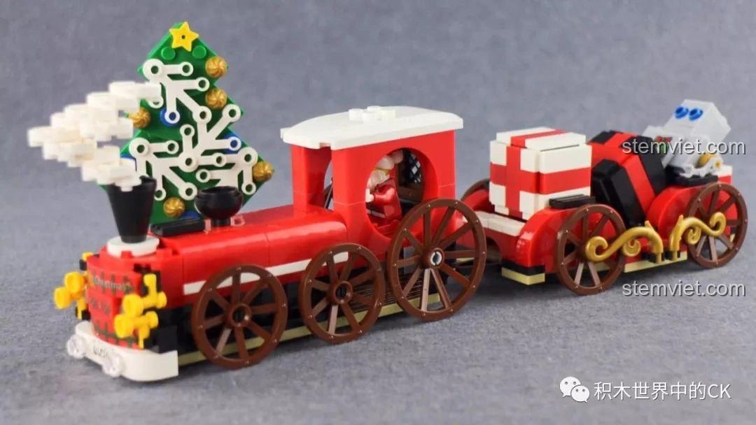 Ảnh Ông Già Noel đang lái tàu hỏa Winner 5036 Tàu Hỏa Giáng Sinh Trắng, trong khi chú robot ngồi thư giãn trên toa quà, tạo nên một cảnh tượng vui nhộn và hài hước, thu hút bé 6 tuổi.