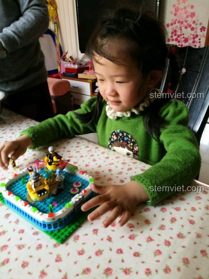 Bé gái đang chơi với mô hình Vịt Quay Winner 7041, thể hiện sự thích thú.