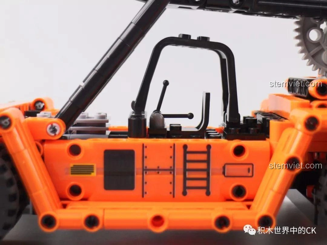 Bàn tay đang thao tác điều khiển bánh răng trên mô hình Winner 7059 Xe Nâng Gắp Container, cho thấy tính năng hoạt động.