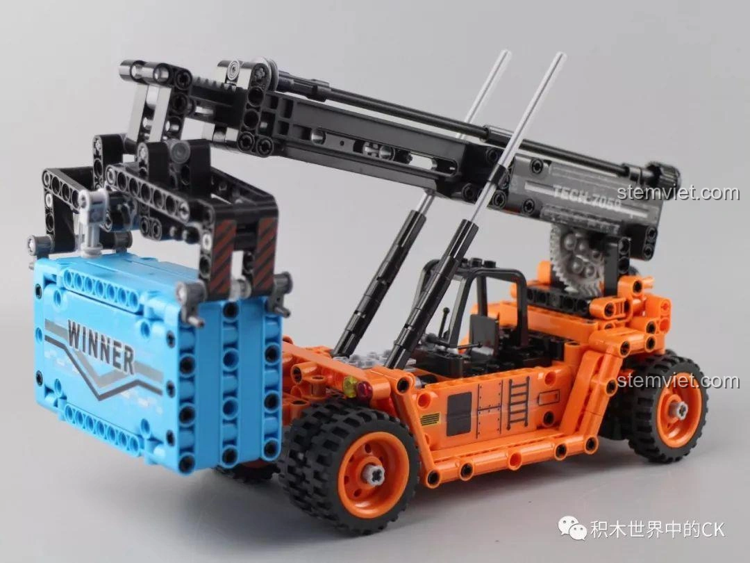 Góc nhìn cận cảnh mô hình Winner 7059 Xe Nâng Gắp Container hoàn chỉnh, với container đang được nâng.