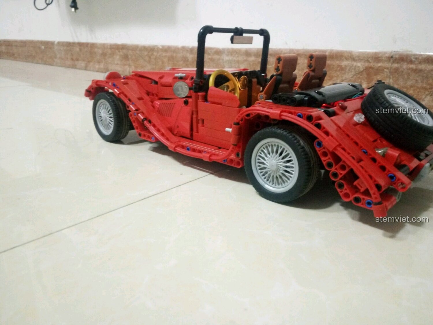 Đồ chơi mô hình Winner 7062 Xe Mui Trần Cổ Điển Màu Đỏ nhìn từ góc sau, thể hiện chi tiết thiết kế và bánh xe dự phòng, dành cho bé trai 6 tuổi, chất lượng cao.