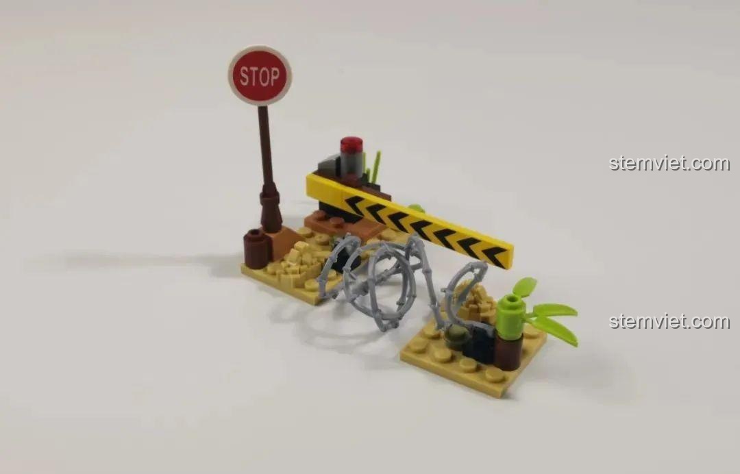Cảnh quan phụ trợ nhỏ gọn với biển báo dừng và hàng rào có thể mở đóng, tăng tính tương tác cho bộ đồ chơi WOMA C0193.