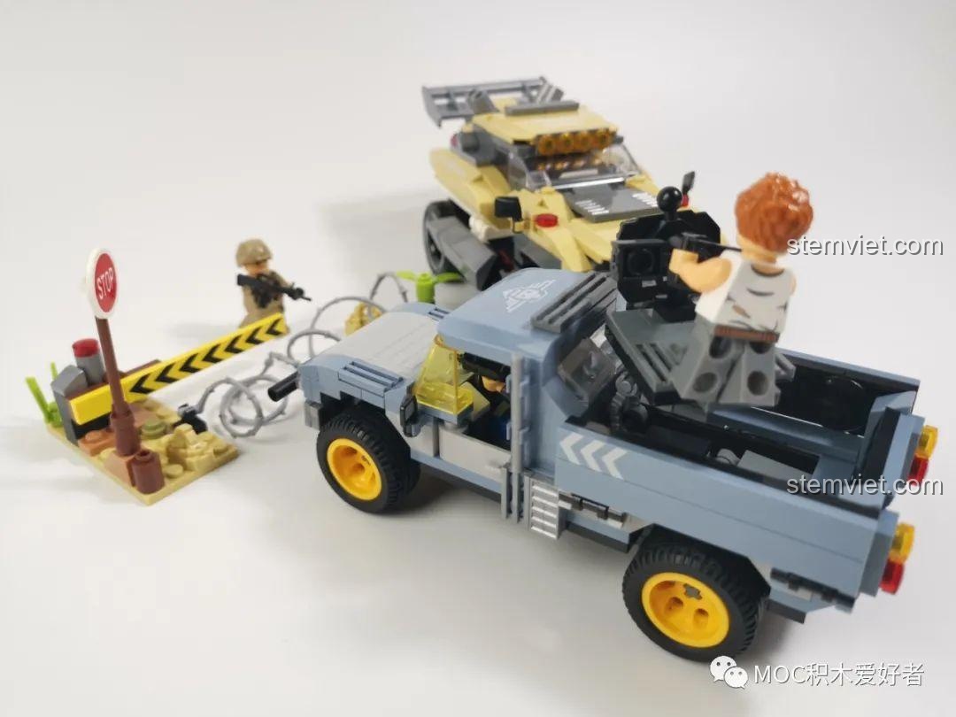 Cận cảnh minifigure đang điều khiển khẩu súng Gatling trên xe bán tải quân sự WOMA C0193, chi tiết và sống động.