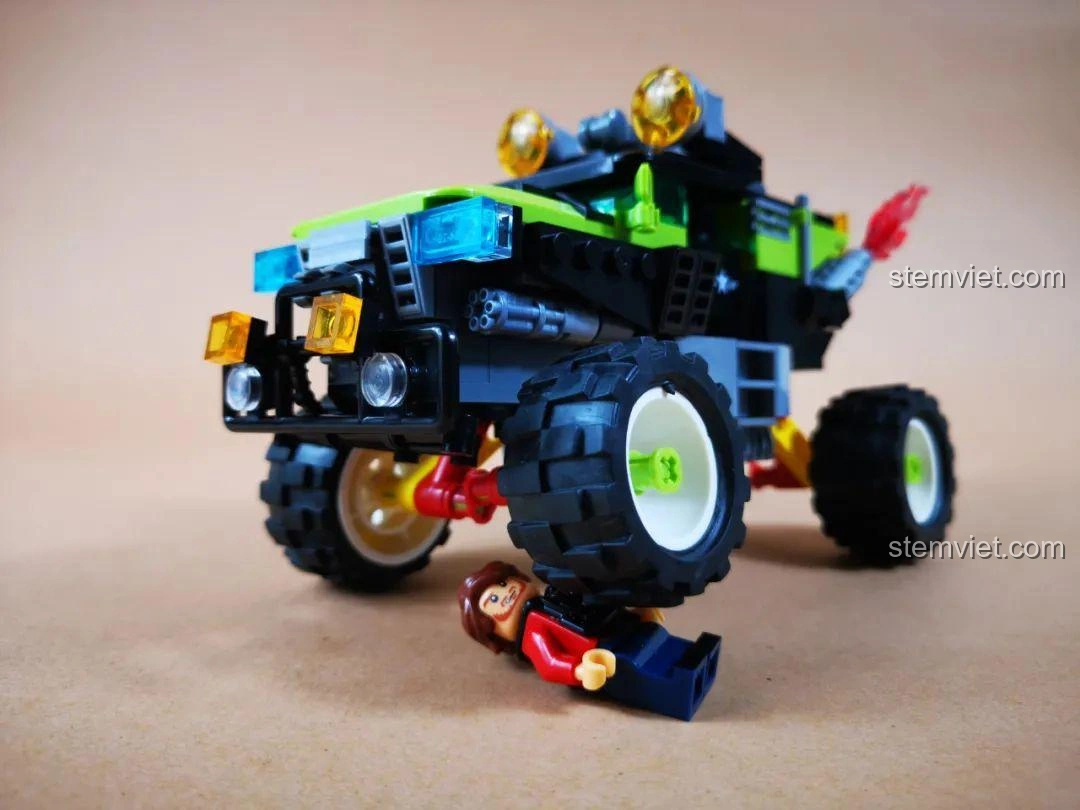 Minifigure nằm dưới bánh xe Jeep Quân Sự WOMA C0195, minh họa khả năng hoạt động của hệ thống treo.