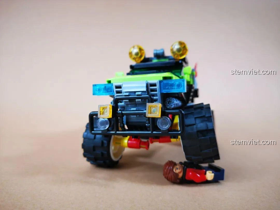 Minifigure bị kẹt dưới bánh xe Jeep Quân Sự WOMA C0195, minh họa độ linh hoạt của hệ thống treo.