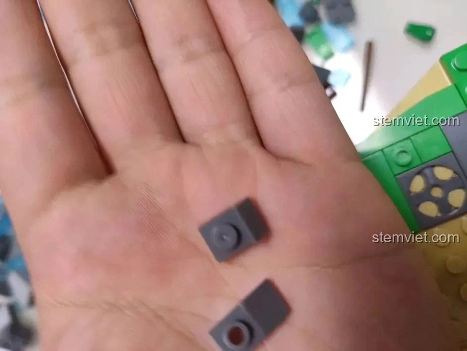 Hai mảnh ghép tấm nhỏ màu xám của bộ WOMA C0348 Đình Phượng Sơ, thể hiện độ chính xác của các chi tiết nhỏ.