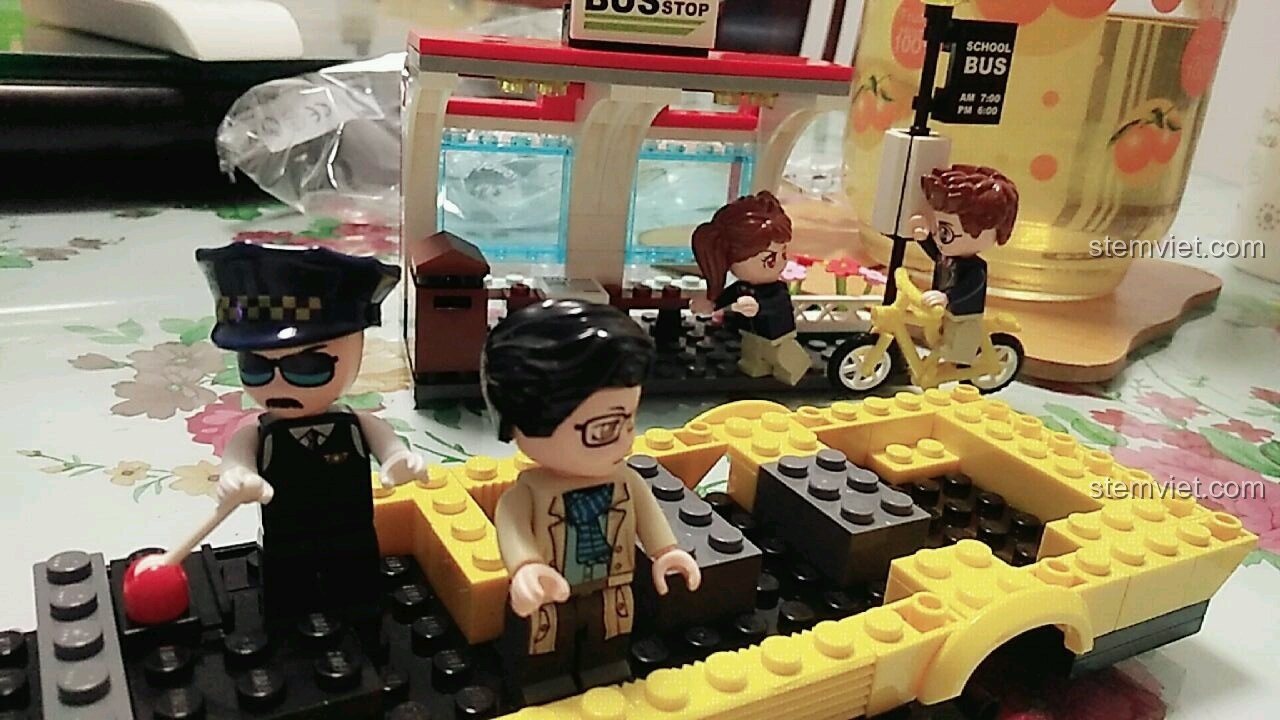 Chiếc xe buýt trường học màu vàng đang được lắp ráp, với các chi tiết ghế ngồi và trạm chờ ở phía sau trong bộ QMAN 1136.