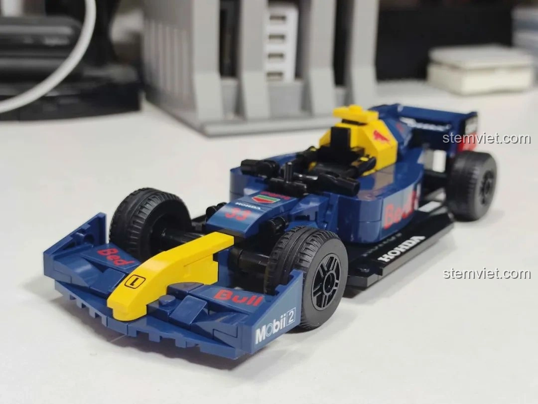 Mô hình xe đua F1 màu cam đã hoàn thiện từ bộ MJ Technology 13014, cùng minifigure người lái.
