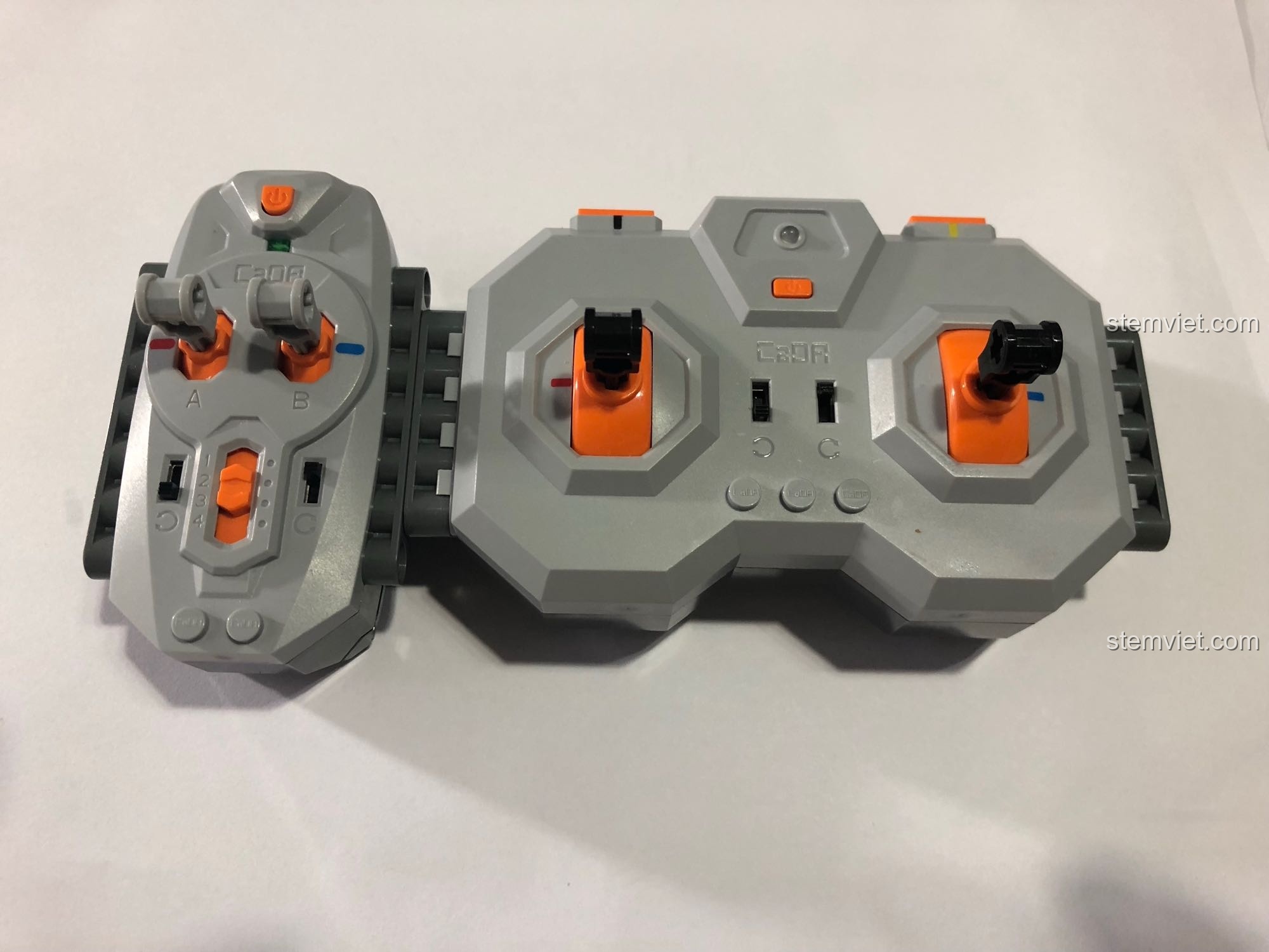 Bộ điều khiển từ xa hai tay cầm, cho phép điều khiển độc lập các chức năng của xe.