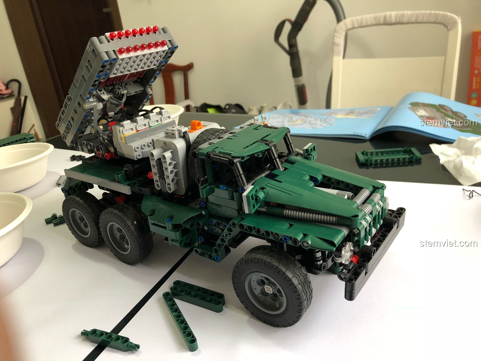 Xe Pháo Phản Lực BM-21 đang được đặt trên một cuốn sách, thể hiện khả năng vượt địa hình.