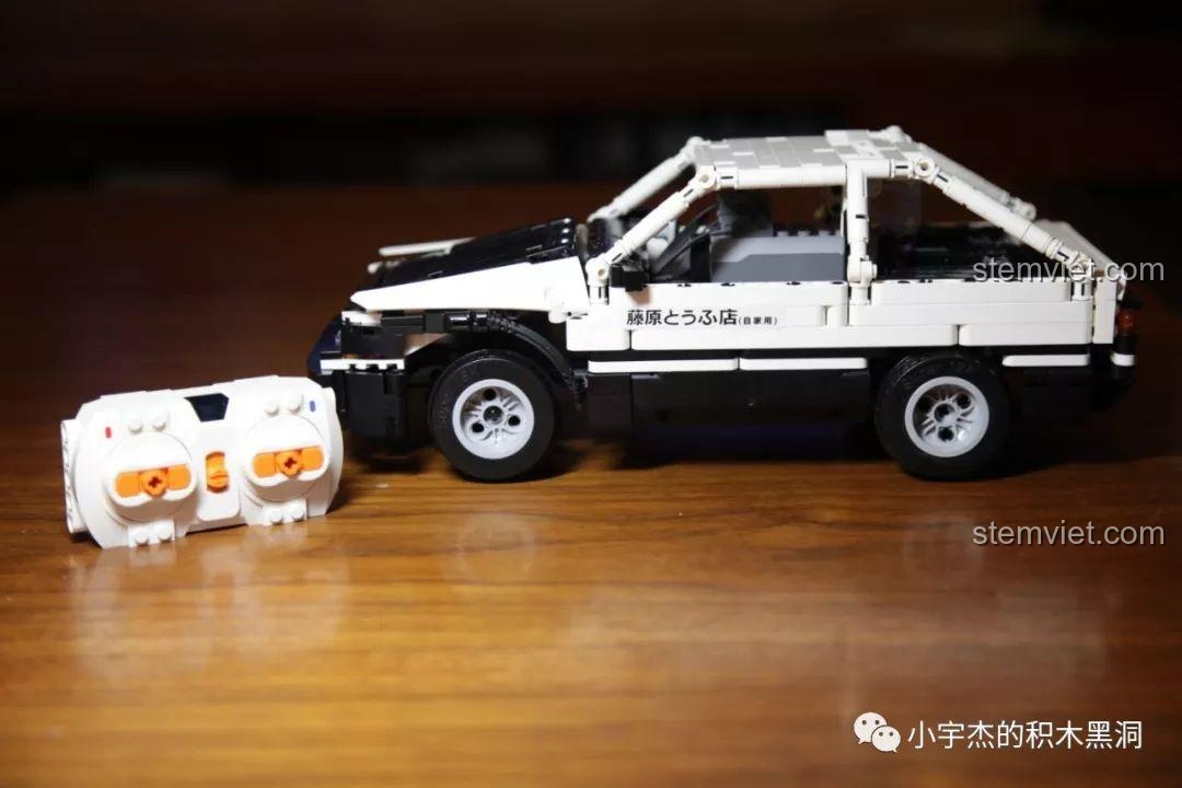 Mô hình xe Super 18K K-81 hoàn chỉnh đặt cạnh bộ điều khiển từ xa màu trắng.