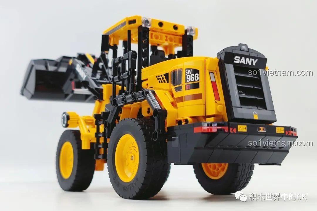 Góc nhìn từ phía sau của xe xúc lật Sembo 712016 khi đang nâng cao gầu xúc, thể hiện sự vững chãi của mô hình.