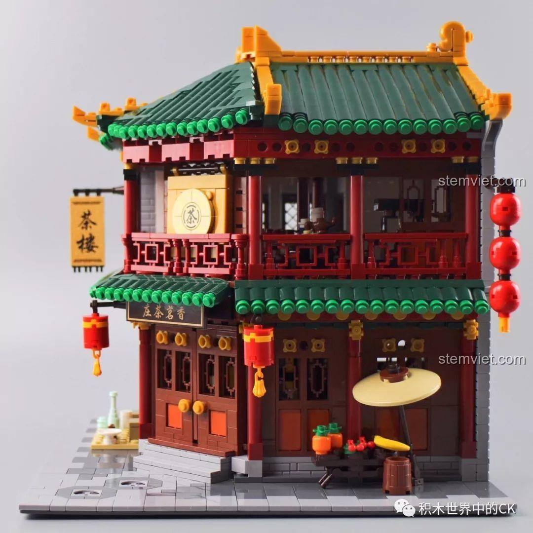 Góc nhìn cận cảnh mặt tiền Trà Quán Hương茗 với đèn lồng đỏ, biển hiệu và quầy hàng rong.