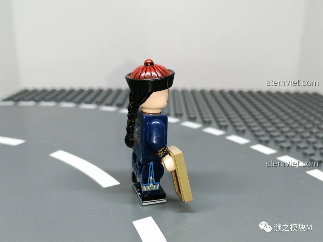Minifigure Quan văn nhất phẩm từ góc nghiêng, thể hiện chi tiết mũ quan và bím tóc dài đặc trưng Triều Thanh. Đồ chơi lắp ráp lịch sử.