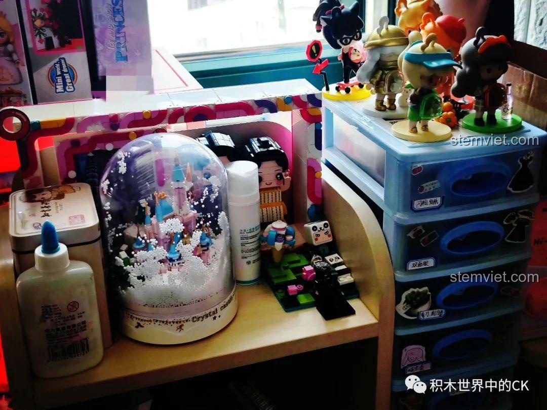 Bé gái vui vẻ chỉ vào mô hình ZHEGAO 01043 Lâu đài Pha Lê đã hoàn thành, thể hiện niềm tự hào và sự yêu thích.