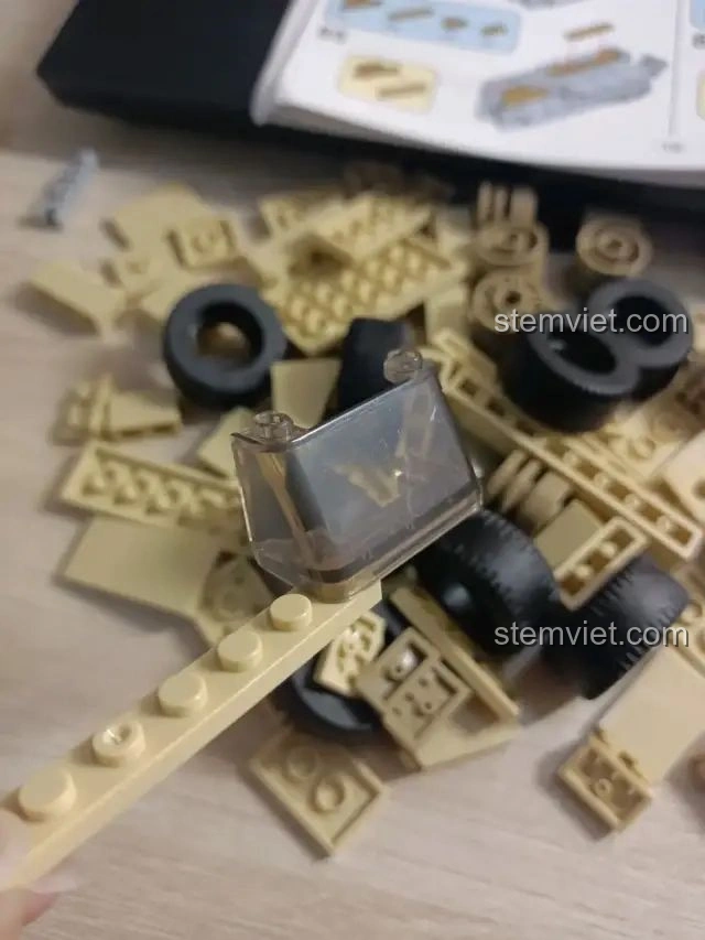 Cận cảnh các mảnh ghép màu be của bộ lắp ráp Zhegao QL0176, bao gồm cả bánh xe và một mảnh trong suốt, cho thấy chất lượng nhựa ABS cao cấp.