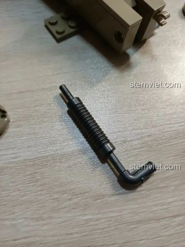 Cận cảnh một chi tiết lò xo/piston màu đen của bộ lắp ráp Zhegao QL0176, thể hiện độ tinh xảo của các mảnh ghép.