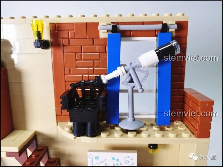 Một góc học tập khác bên trong đồ chơi xây dựng Dãy nhà phố cổ điển, với kính thiên văn nhìn ra cửa sổ.