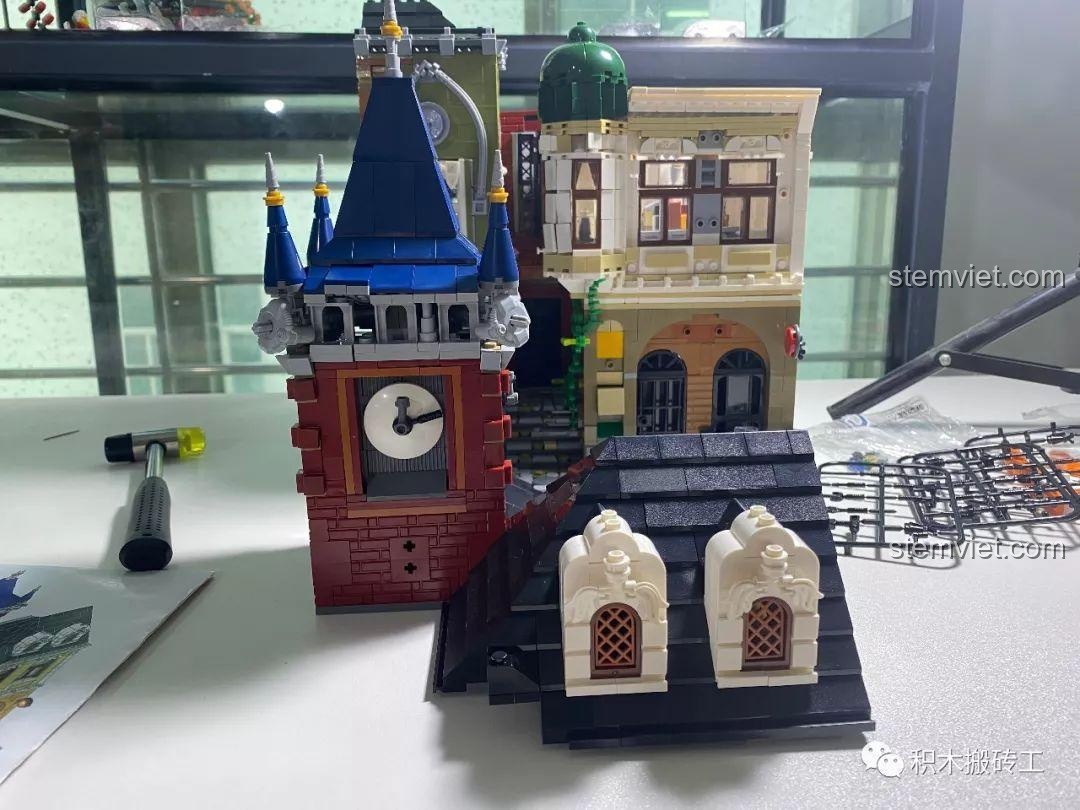 Phần đế tháp đồng hồ của mô hình Kiến trúc Quán Rượu Cổ QL0924, chi tiết các viên gạch đỏ và mặt đồng hồ.