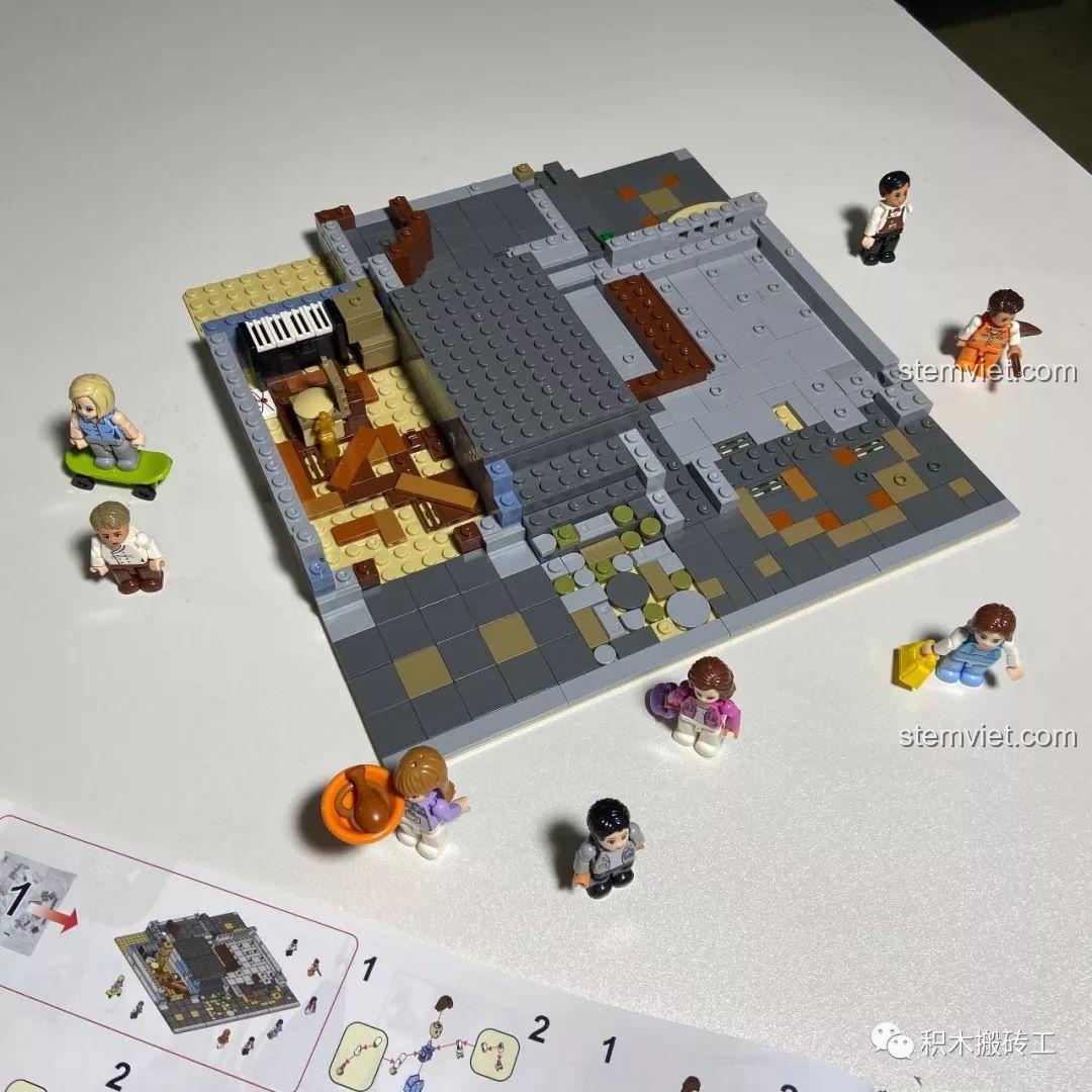 Phần đế và các minifigures sau khi hoàn thành bước 1 của bộ xếp hình ZHEGAO QL0924 Quán Rượu Cổ, thể hiện sự khởi đầu của công trình kiến trúc.