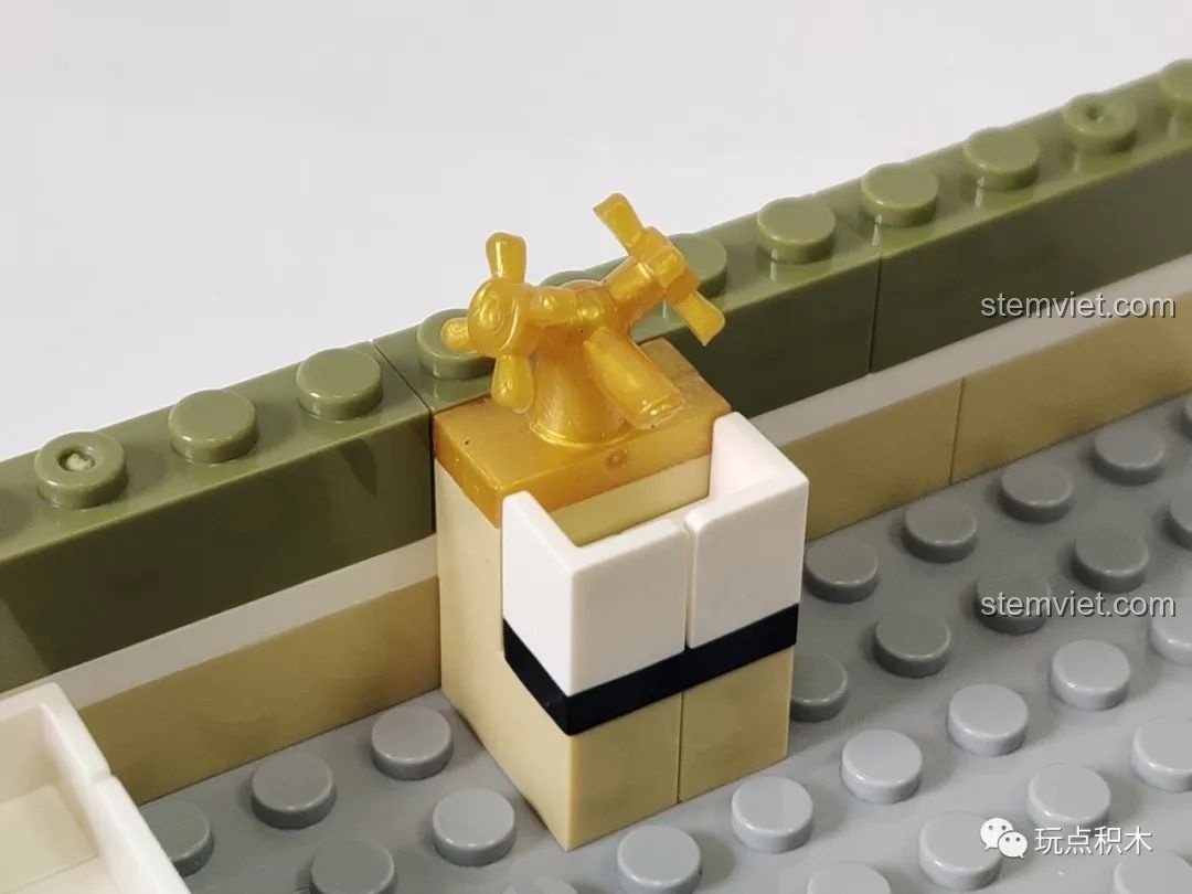 Cận cảnh chi tiết vòi nước màu vàng trong phòng tắm của mô hình Zhegao QL0937, thể hiện sự tinh xảo.