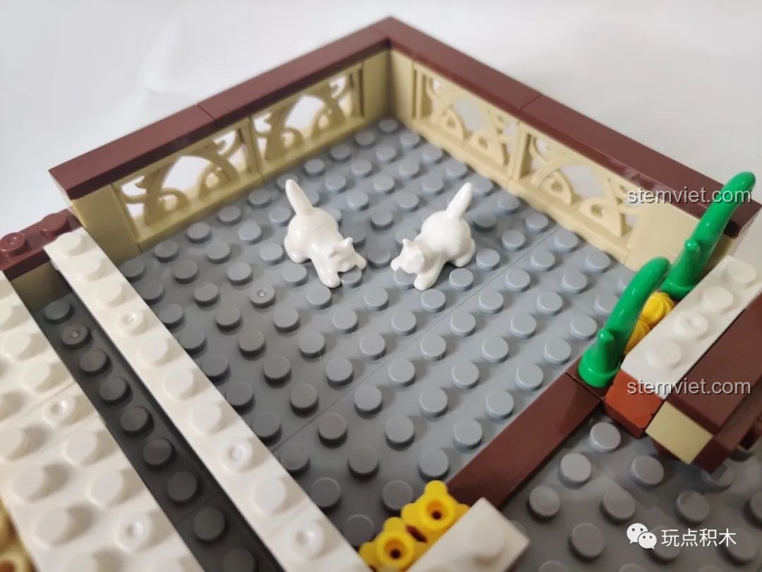 Hai chú mèo trắng đáng yêu trên sân thượng của mô hình Zhegao QL0937, một chi tiết thú vị cho bé.