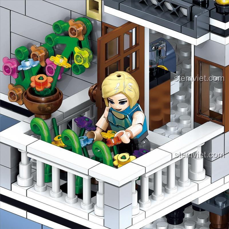 Nhân vật nữ đang chăm sóc vườn hoa trên ban công tầng 2 của mô hình kiến trúc khách sạn Zhegao.